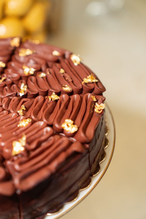 Free Indulge in a decadent chocolate cake adorned with delicate gold leaf Stock Photo