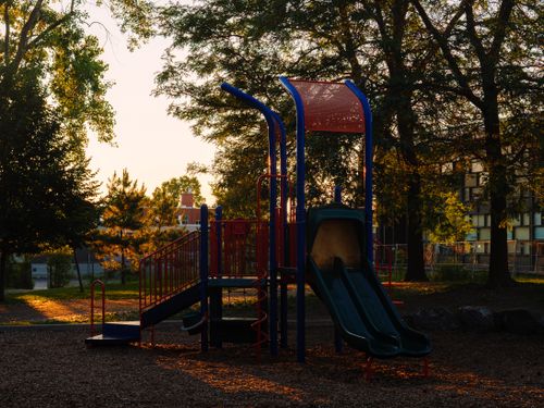 Free Scenic view of a playground slide basking in golden hour sunlight, in a Quebec suburban park. Stock Photo