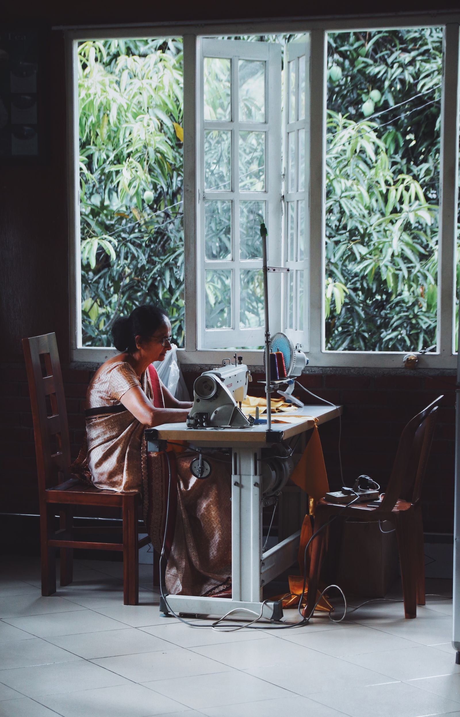 Indian tailor sewing a garment at a sewing machine