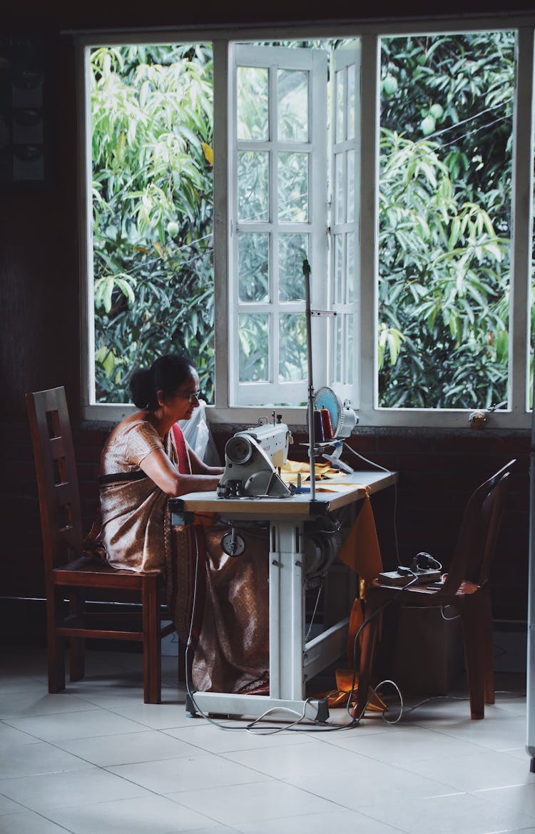 Indian Woman Sewing Dress On Sewing Machine