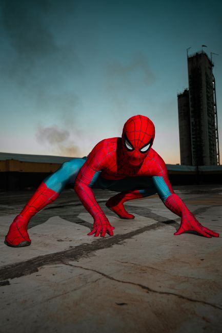 A superhero in costume striking a pose on a rooftop at sunset, exuding strength and agility.