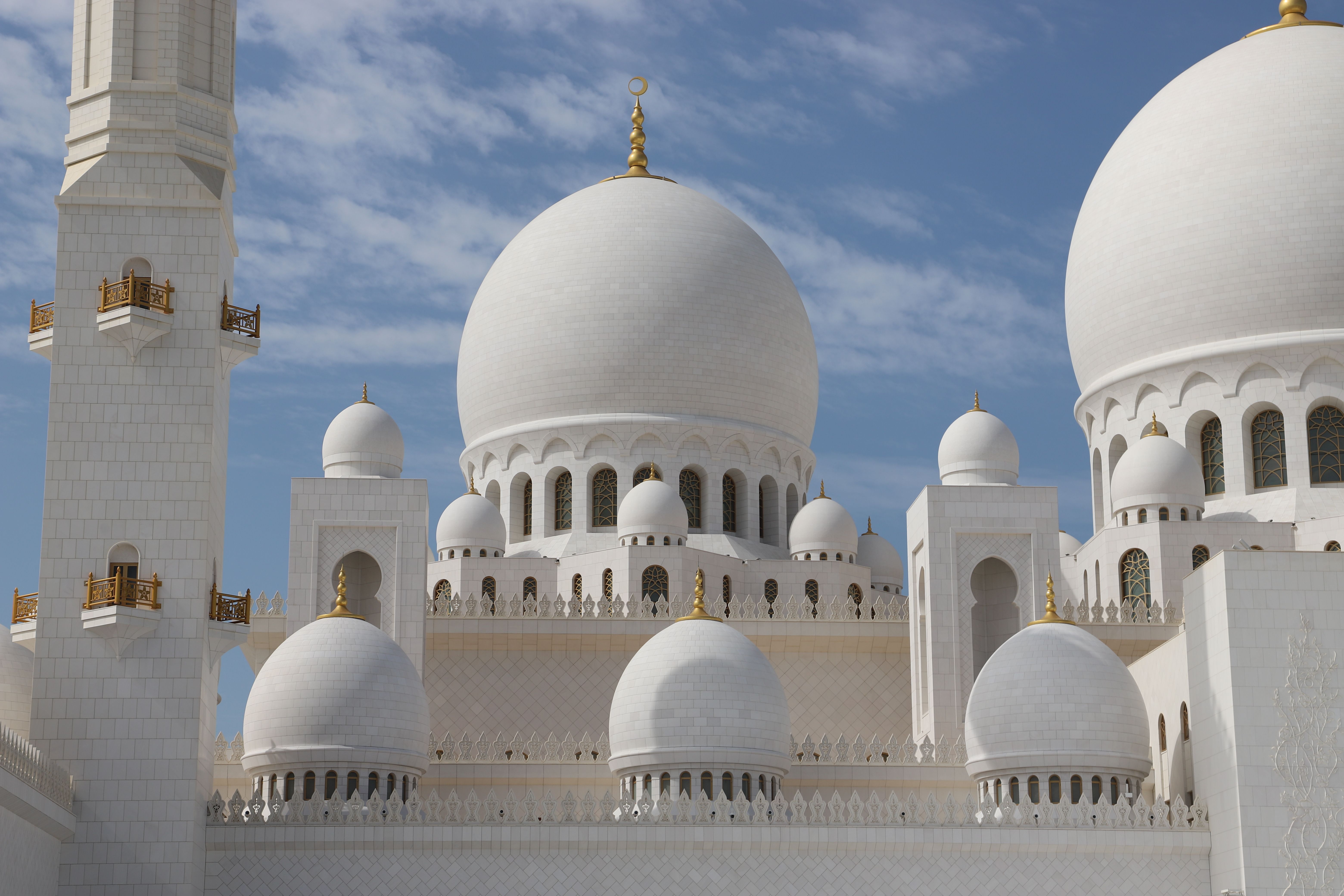 The stunning white marble domes of the Sheikh Zayed Grand Mosque in Abu Dhabi UAE for an Umrah stopover holiday