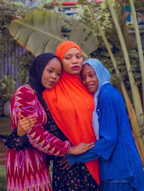 Free Three women embrace in a garden, wearing colorful hijabs and expressing unity and friendship. Stock Photo