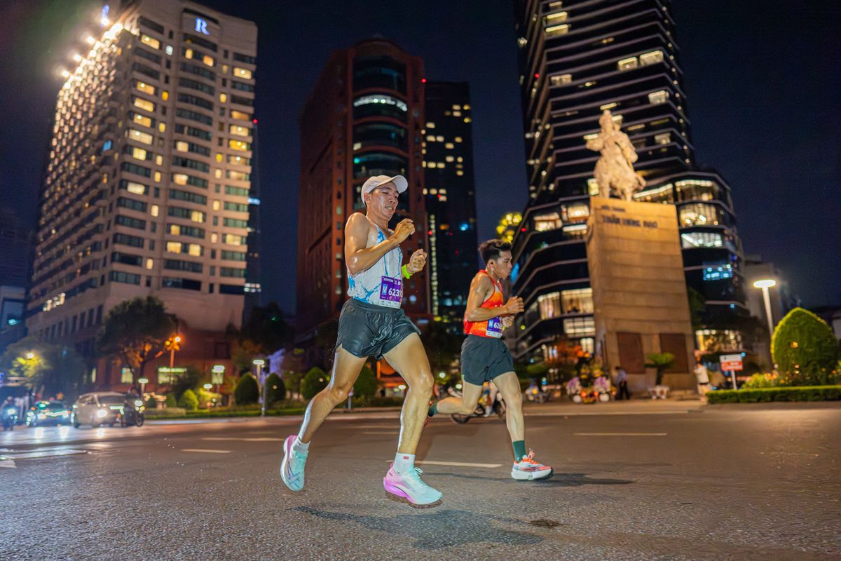 Two runners mid-stride on a closed road at night — photo by VANNGO Ng on Pexels