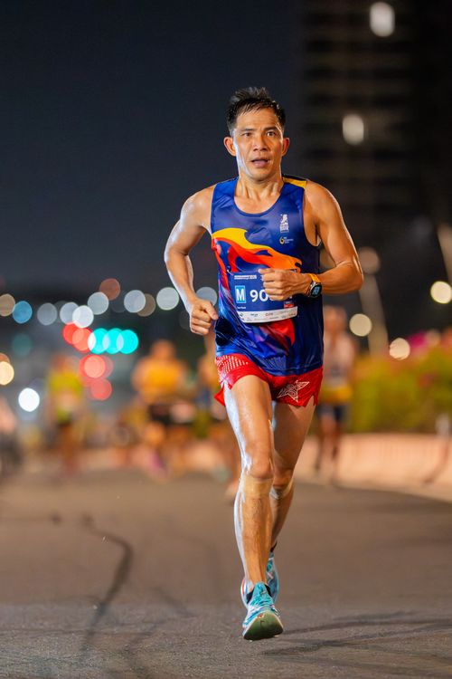 Free Focused runner participating in a night marathon, showcasing determination and athleticism. Stock Photo