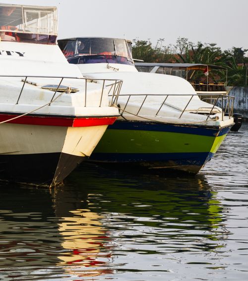Free Two docked boats reflecting on calm water during sunset. Tranquil scene showcasing waterfront leisure. Stock Photo