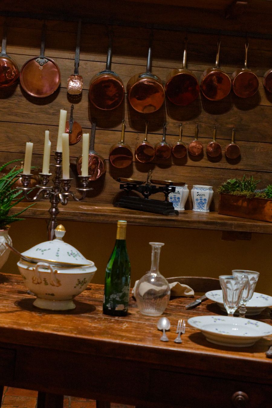 Casseroles en cuivre anciennes et table dressée dans les cuisines du château de Villandry
