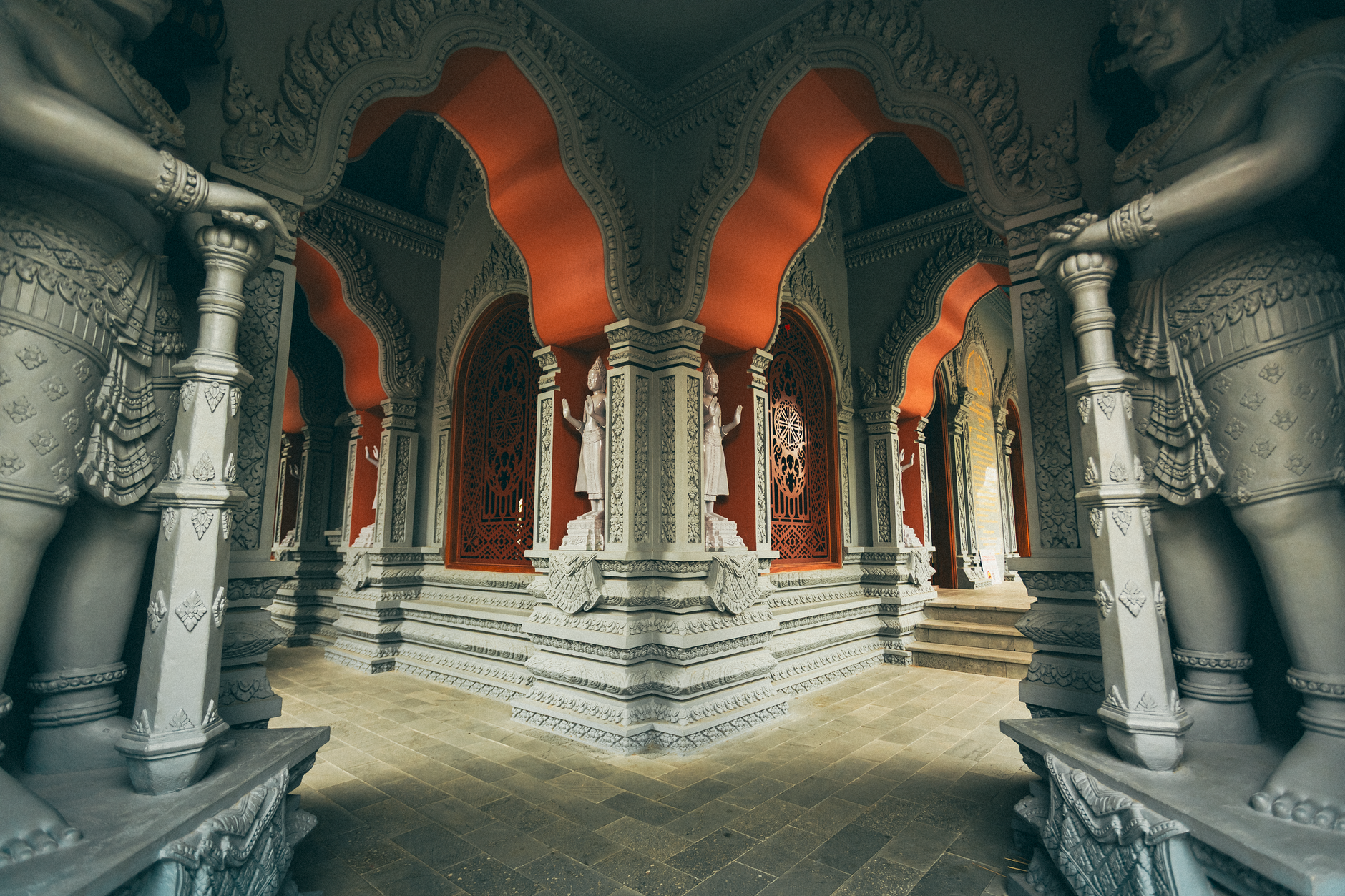 Explore the ornate and colorful interior of a Cambodian-inspired temple with detailed sculptures and archways in Vĩnh Long, Vietnam.