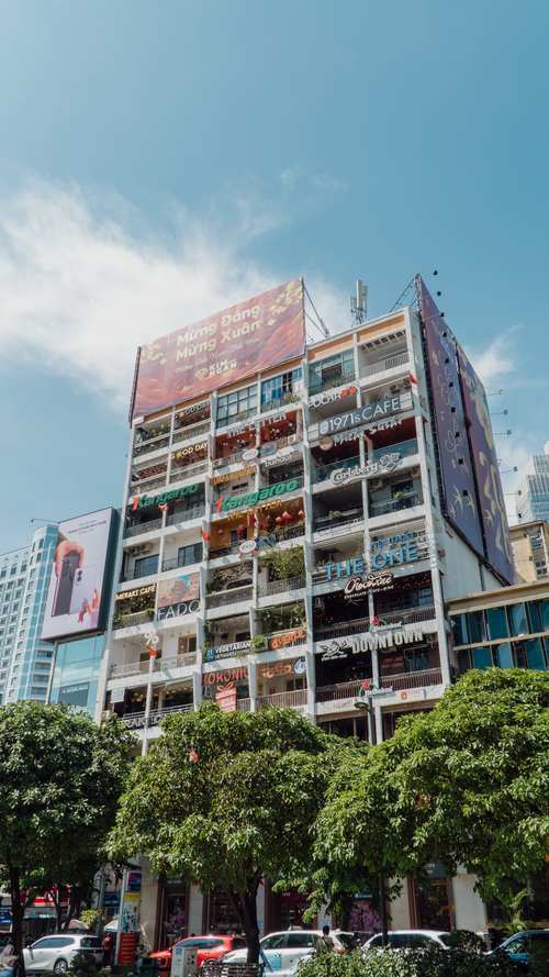 Free Multi-story building filled with cafes on a sunny day in Saigon. Stock Photo