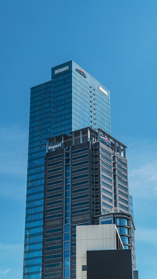 Free Tall modern skyscraper in urban setting against blue sky. Ideal for architecture theme. Stock Photo