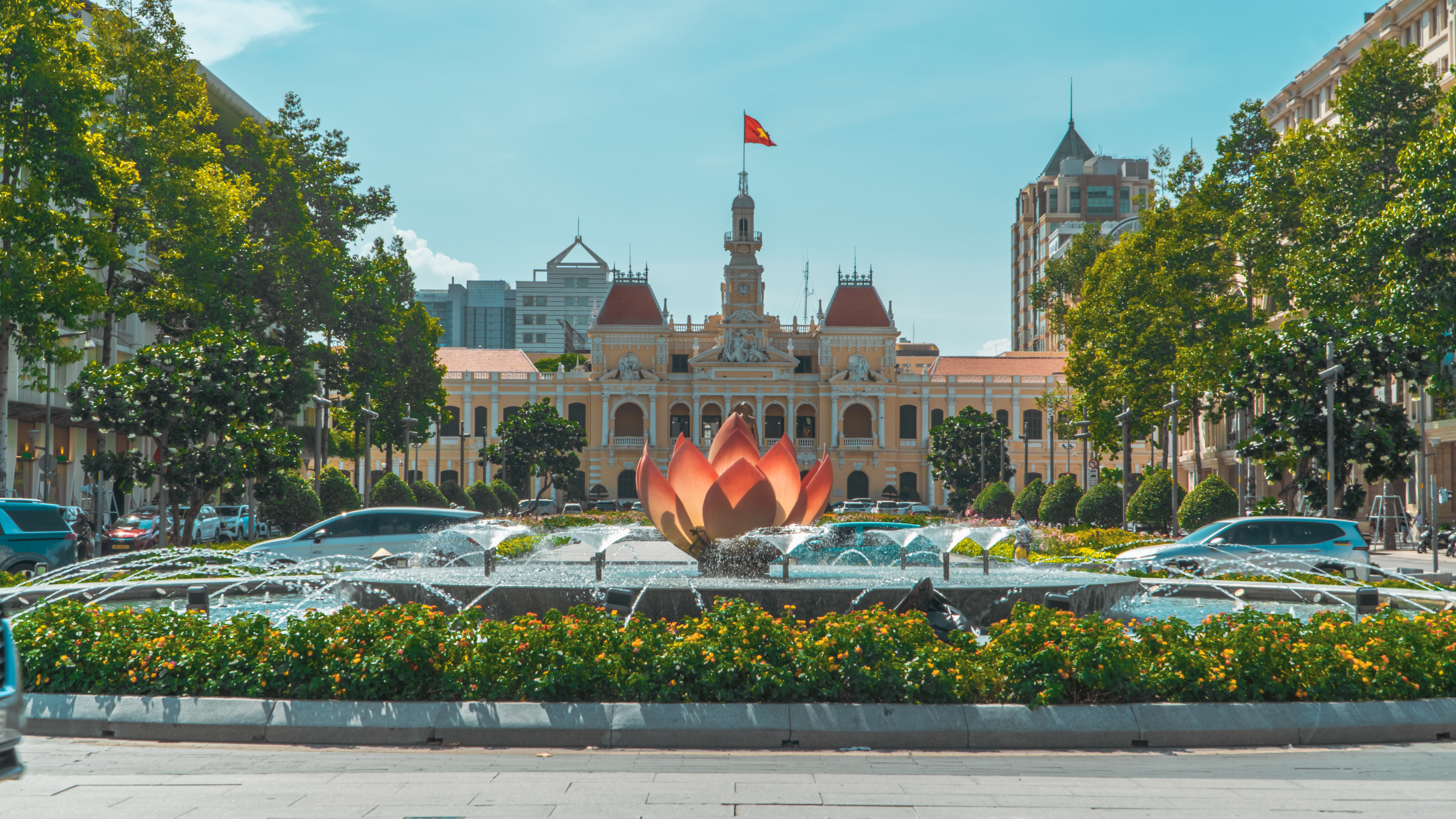 View of Ho Chi Minh City Hall with lotus fountain on a sunny day.
