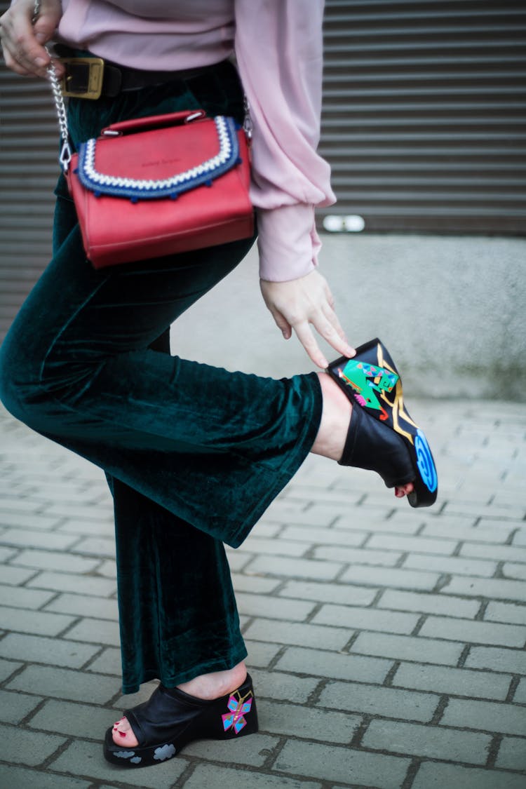 Crop Stylish Woman Touching Shoe Heel On Street