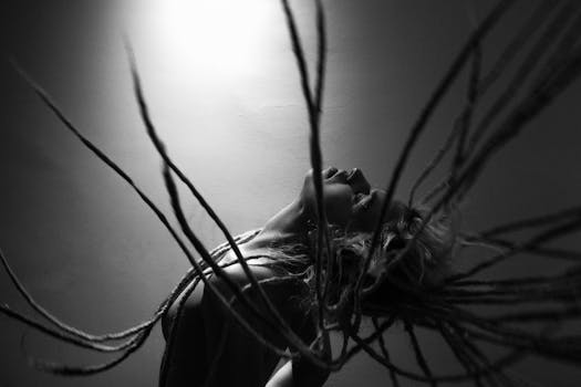 一幅黑白肖像，背景朴素，人物留着辫子，运动姿态表现力鲜明