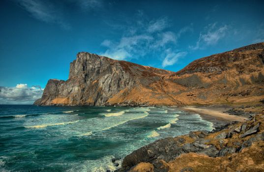 Stunning view of rocky cliffs and ocean waves in Nordland, Norway.