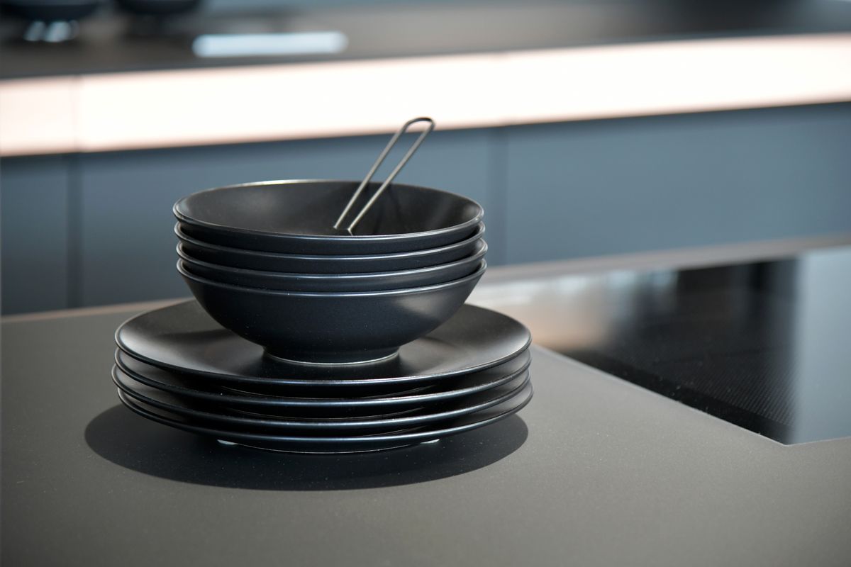 Refined stacked ceramic bowls and plates in a modern kitchen setting