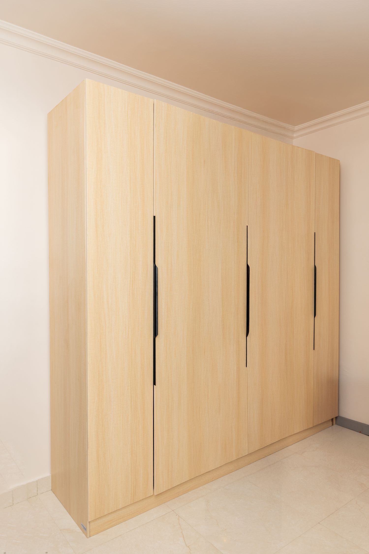 Contemporary fitted wooden wardrobe in a bright bedroom