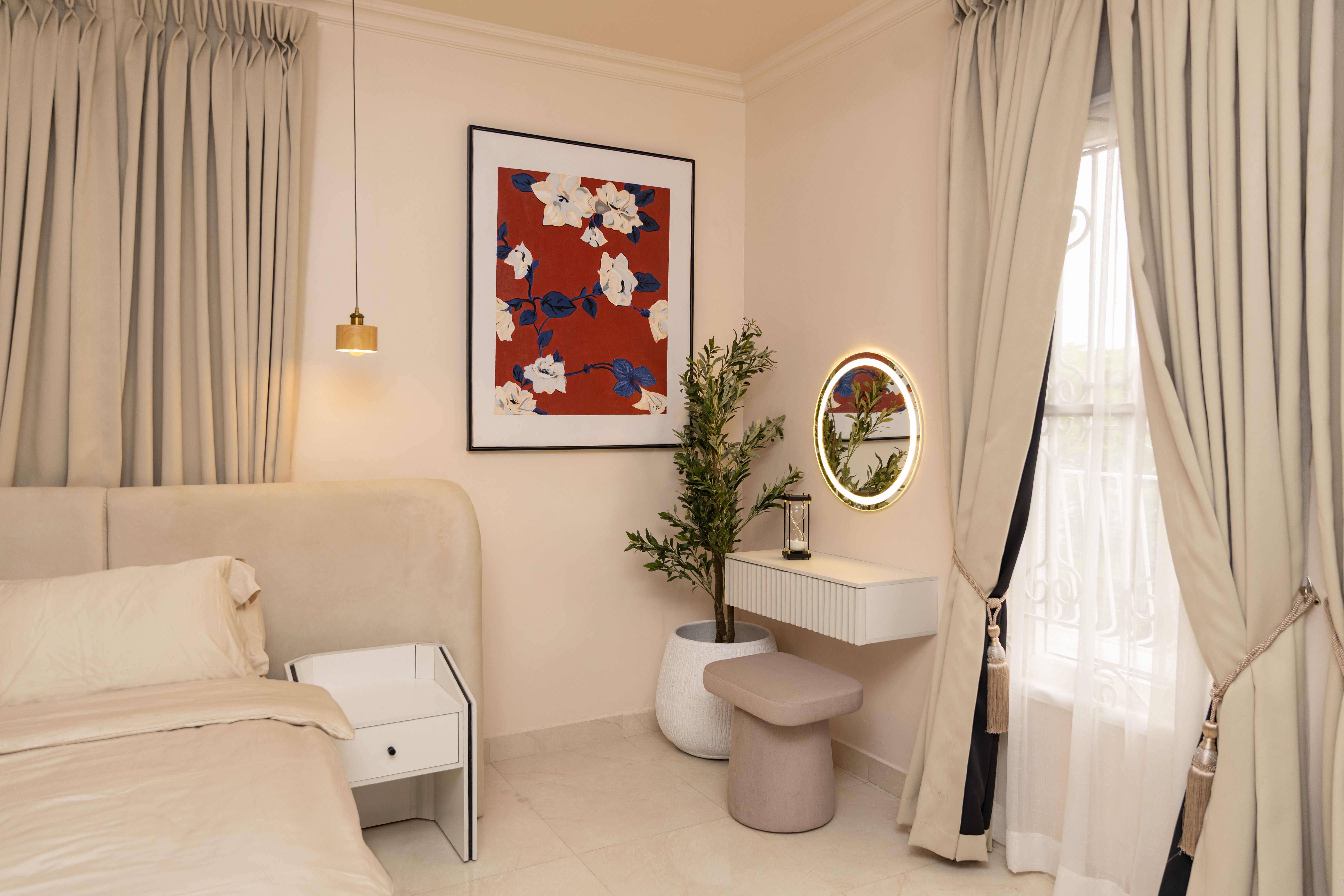 Stylish bedroom interior featuring modern design with floral artwork, soft lighting, and elegant furniture.