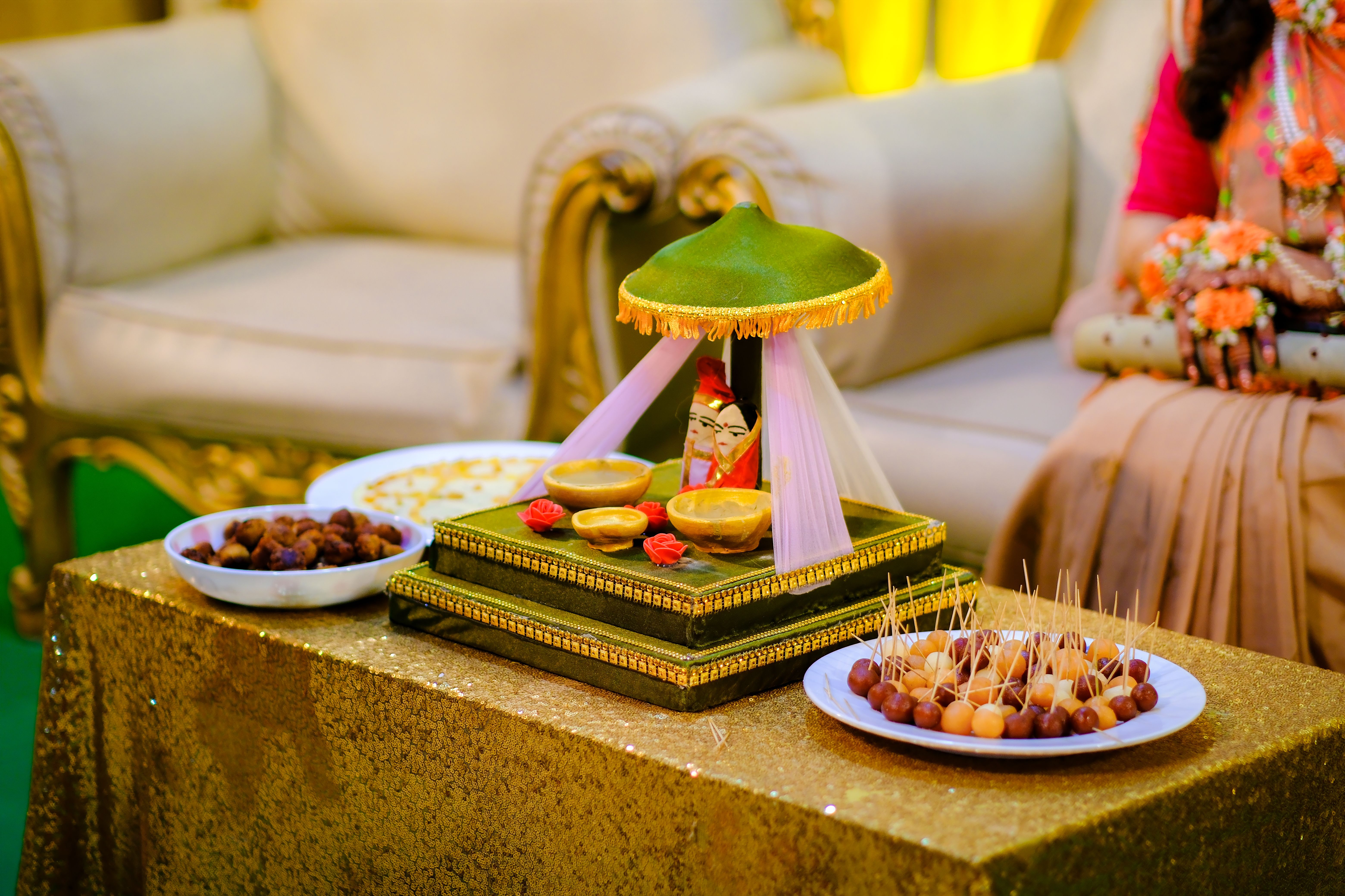 Vibrant Indian engagement setup with traditional decor and assorted snacks.