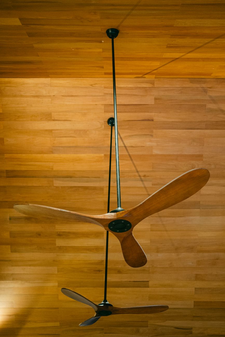 Ceiling fan blades being cleaned with a cloth