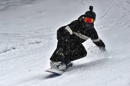 Free Person in Black Jacket and Black Pants Riding on Snowboard Stock Photo