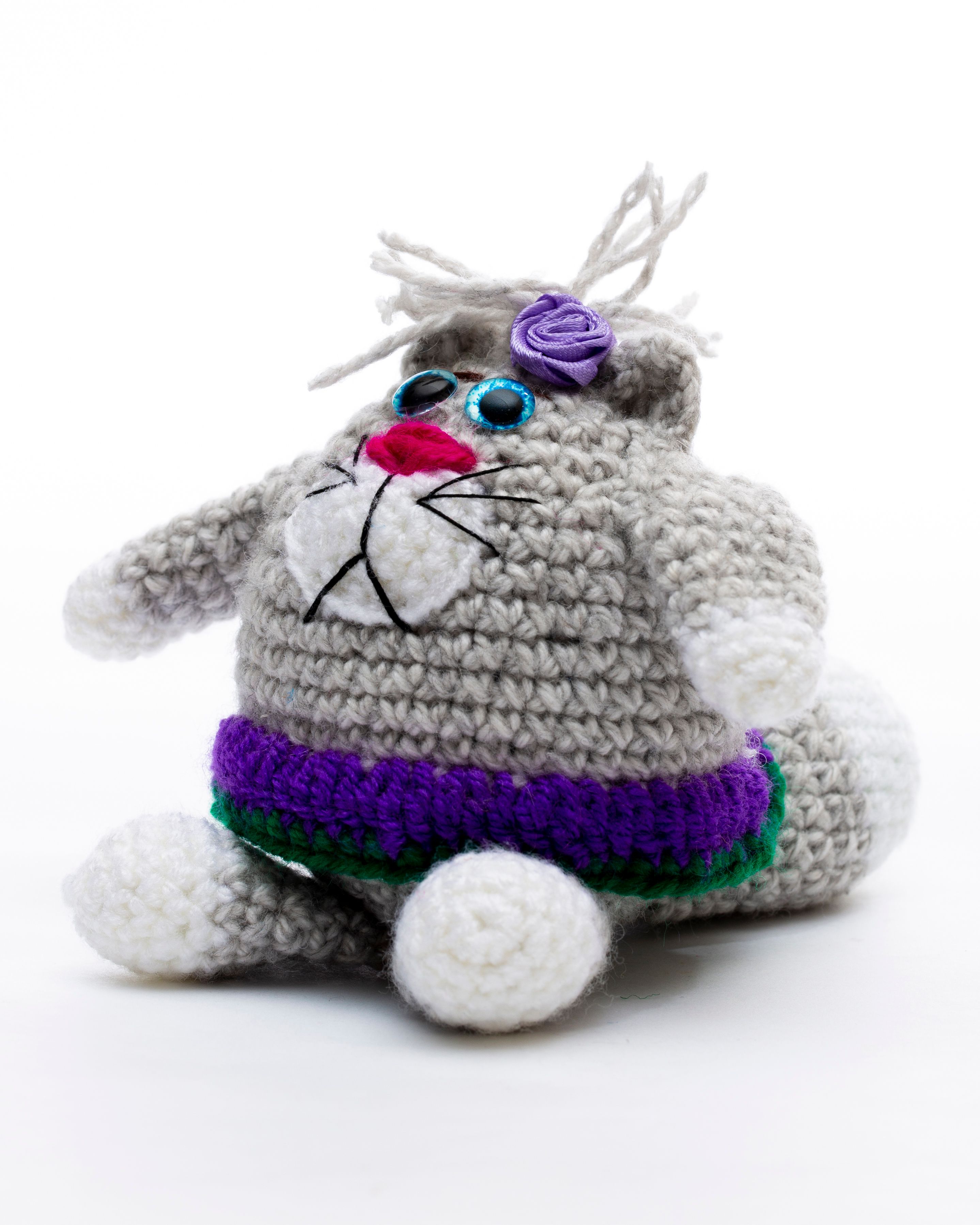 Cute gray crochet plush toy resembling an animal with purple and green accents, perfect for kids.