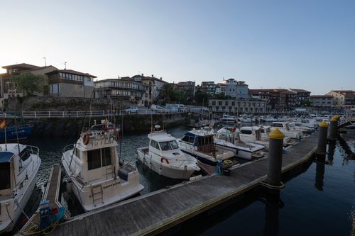 Free Serene marina view with numerous boats docked at sunrise, surrounded by charming buildings. Stock Photo