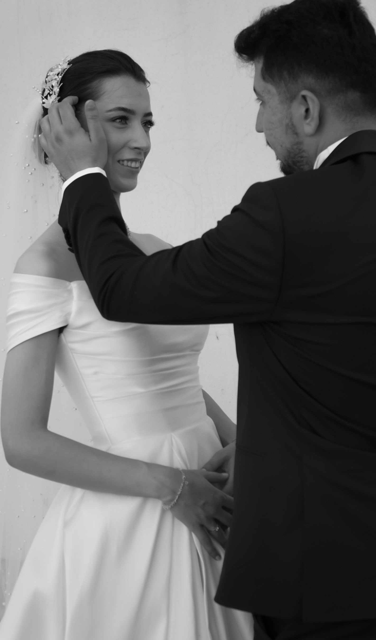 Charming black and white photo of a couple sharing a joyful moment on their wedding day.