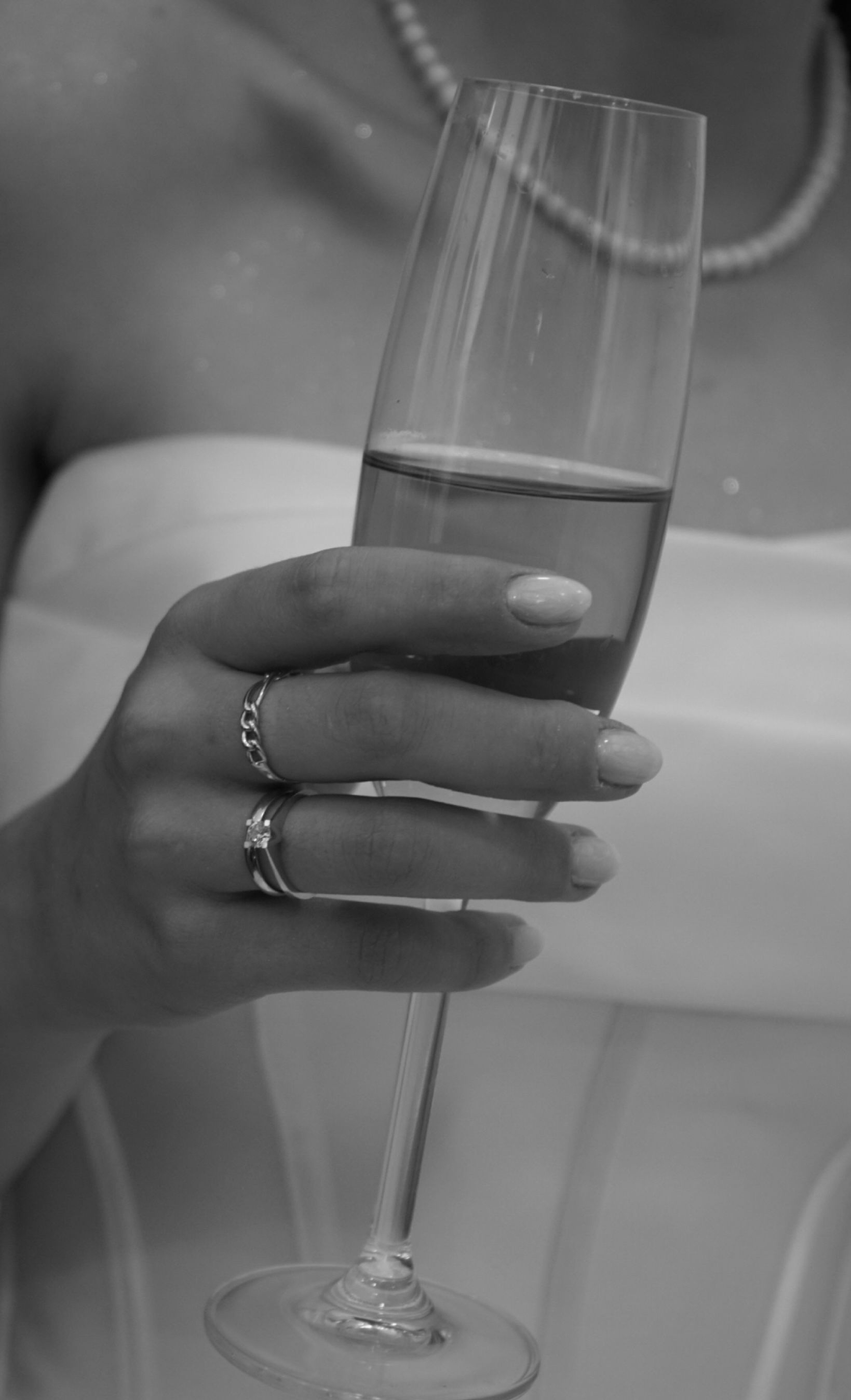Close-up of a woman in a gown holding a champagne glass, celebrating in style.