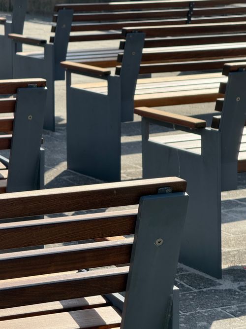 Free Stylish wooden benches with metal frames in a sunny outdoor area. Stock Photo