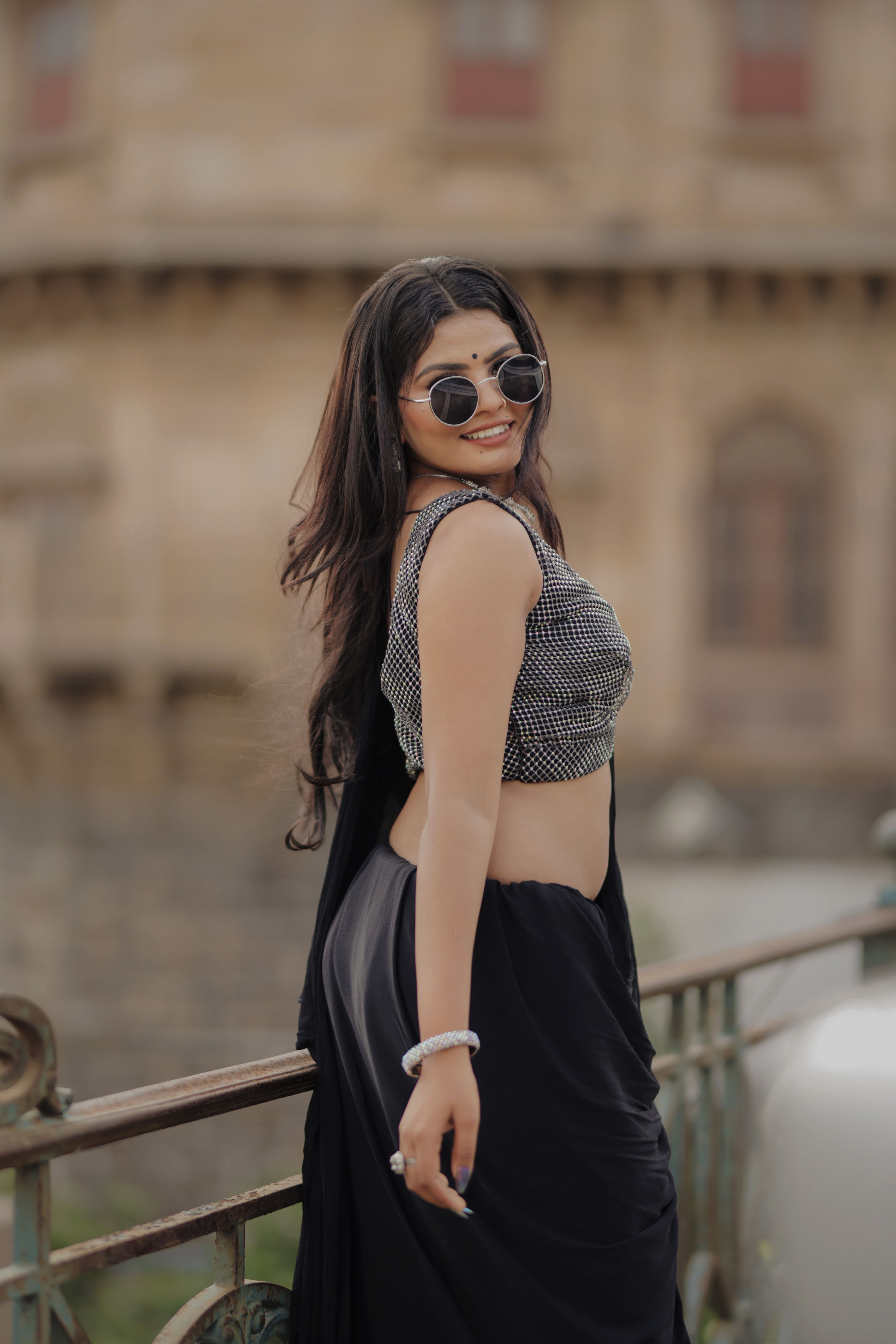 Confident woman in sunglasses posing outdoors in fashionable attire