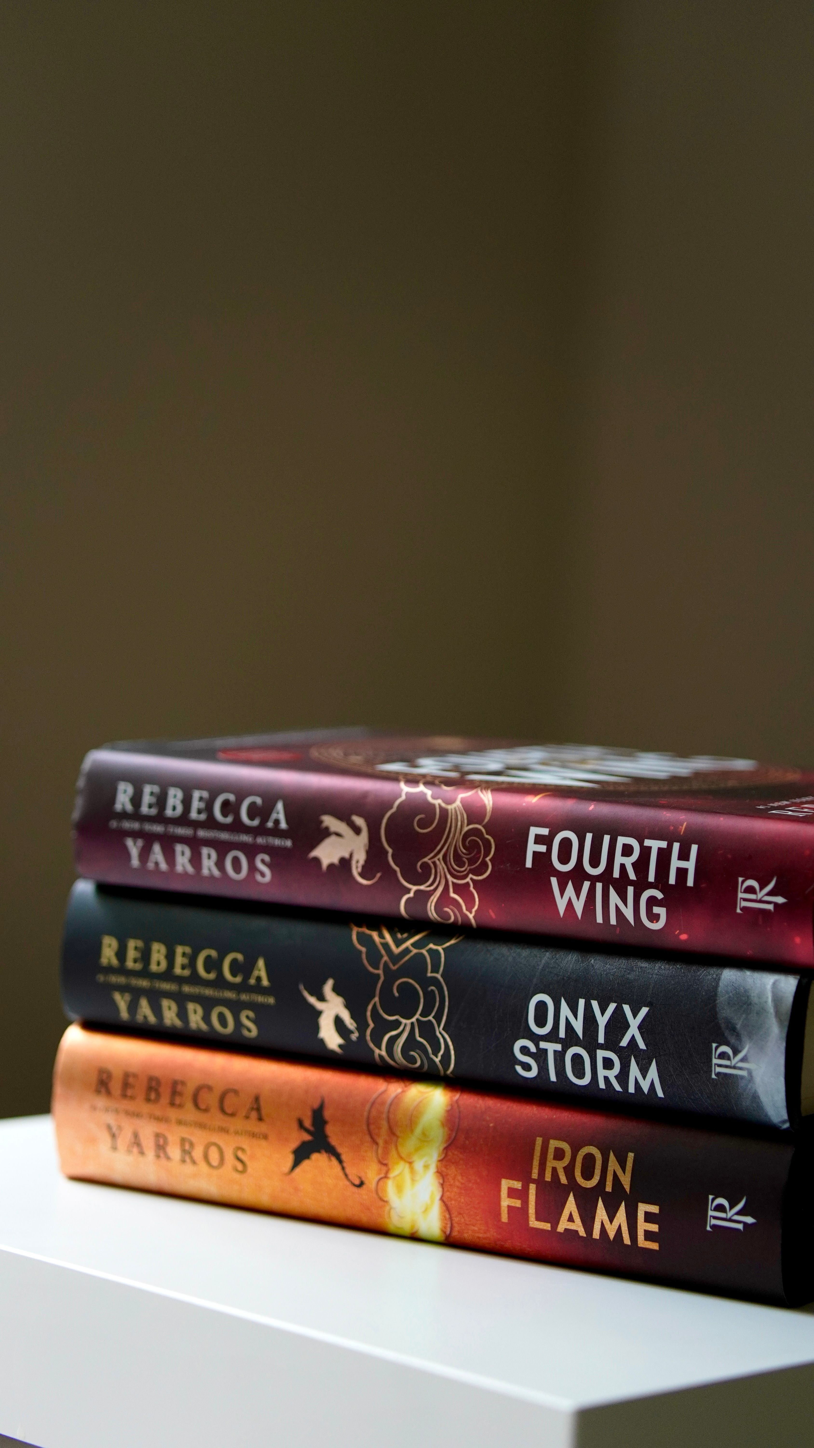 Close-up of three fantasy books by Rebecca Yarros stacked on a table.