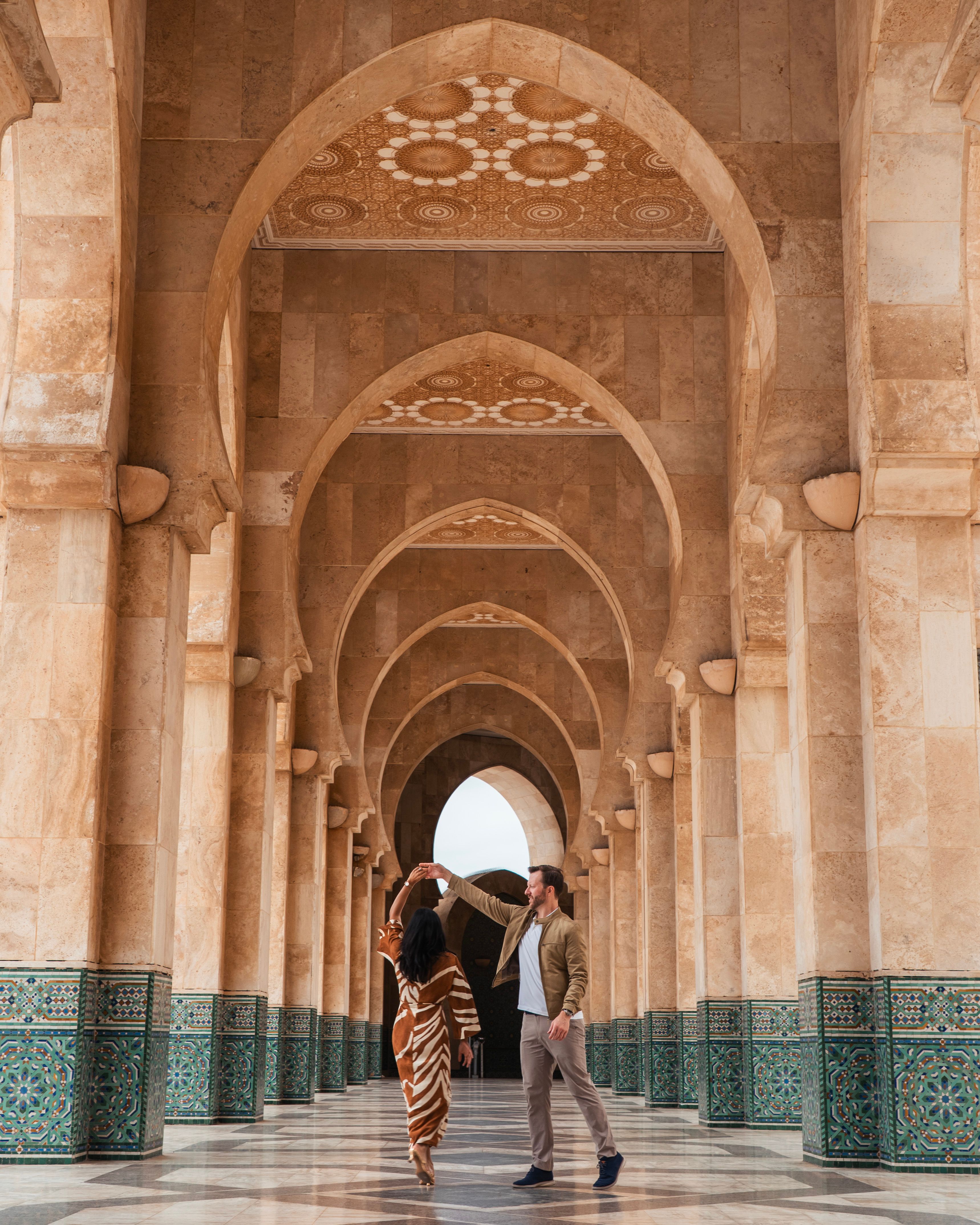 A couple dances under intricately designed arches of Hassan II Mosque in Casablanca, Morocco.