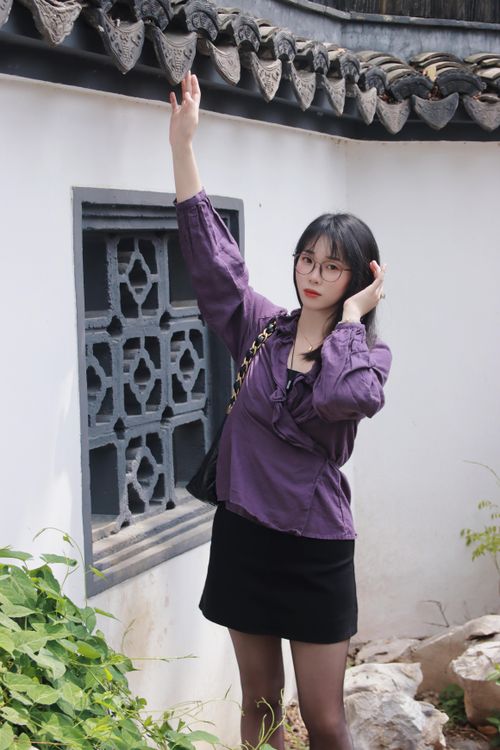 Free A stylish woman poses against a traditional Chinese wall in Nanjing, Jiangsu Province, China. Stock Photo