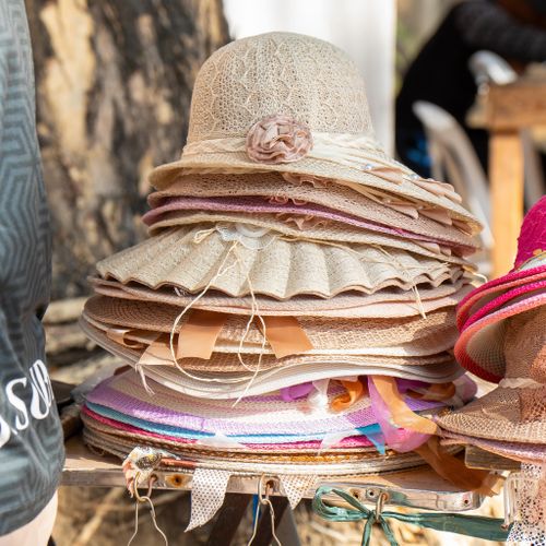 Free A collection of stylish and colorful straw hats displayed outdoors in bright sunlight. Stock Photo