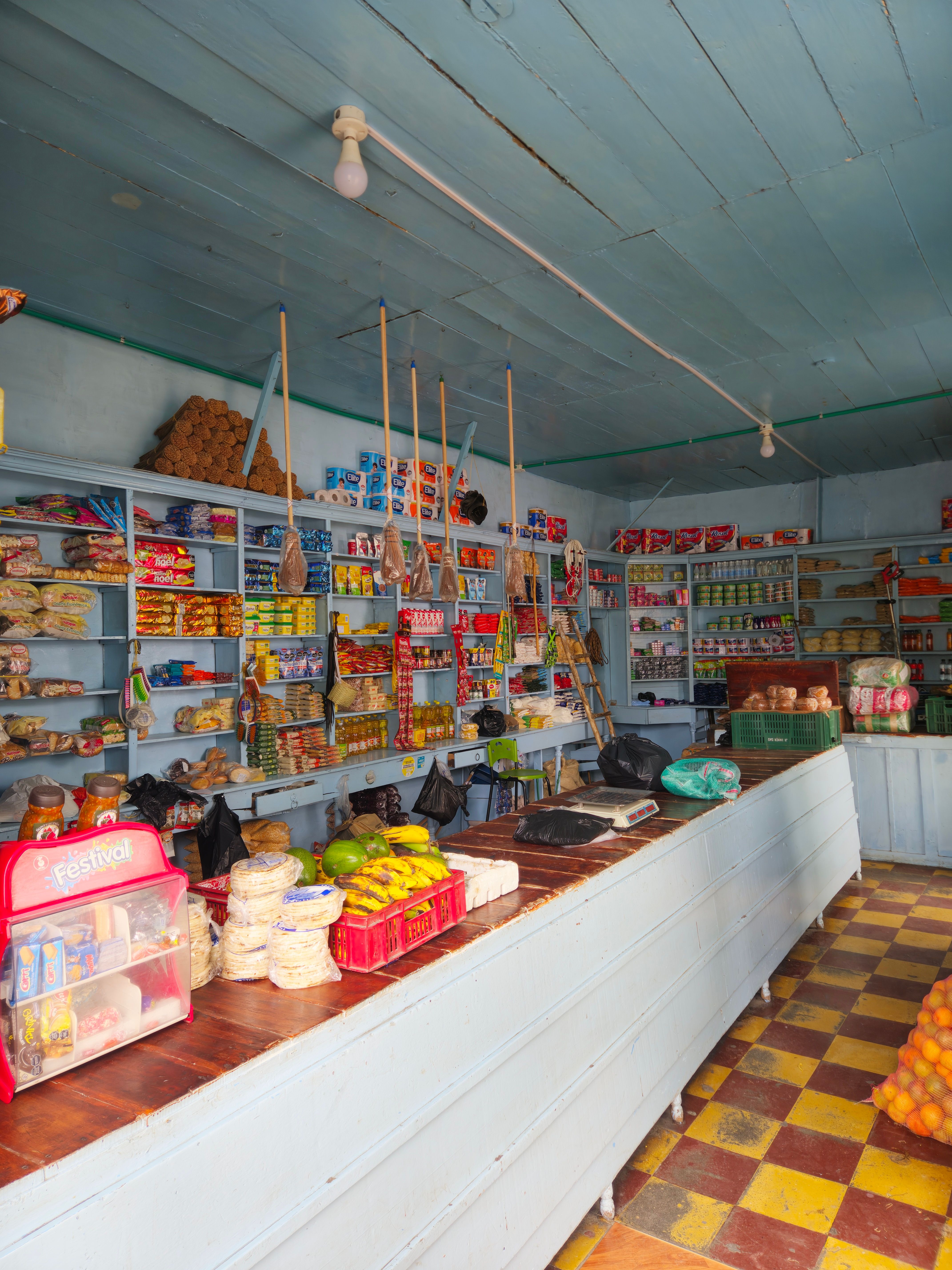 Interior de una tienda de barrio con estantes llenos de productos