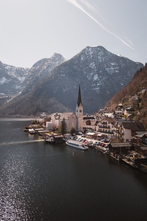 Free A stunning view of Hallstatt village in Austria, nestled by a tranquil lake and surrounded by alpine mountains. Stock Photo