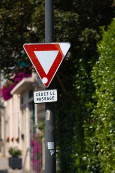 A yield sign in a quiet street in Dol-de-Bretagne, Brittany, France, during the day.