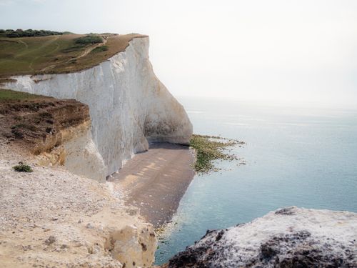Free Breathtaking view of the iconic white chalk cliffs meeting the serene ocean waters. Stock Photo