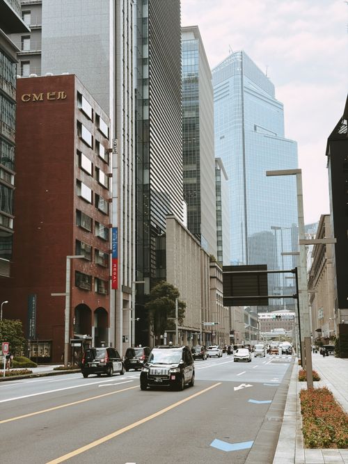 Free View of a busy urban street in Tokyo lined with modern skyscrapers and traffic. Stock Photo