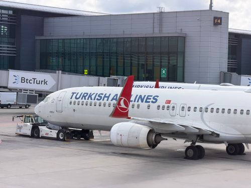 Free Turkish Airlines plane preparing for departure at Istanbul Airport, parked at a terminal gate. Stock Photo