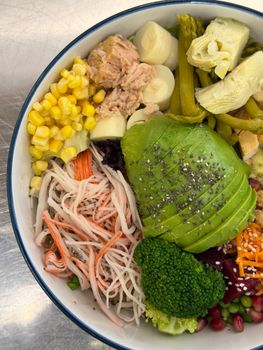 Vibrant salad bowl featuring avocado and fresh vegetables for a nutritious meal.