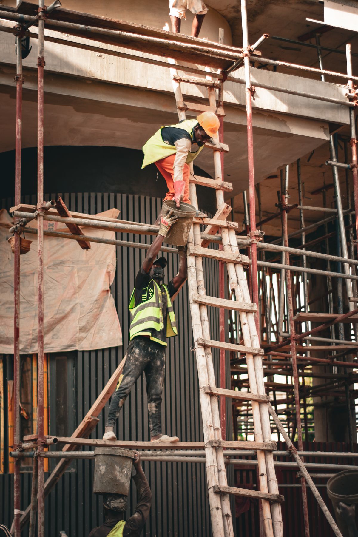 Dois trabalhadores com equipamento de segurança em andaime
