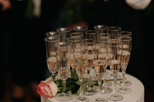 Free Champagne glasses arranged elegantly on a table with a pink rose for a celebration or event. Stock Photo