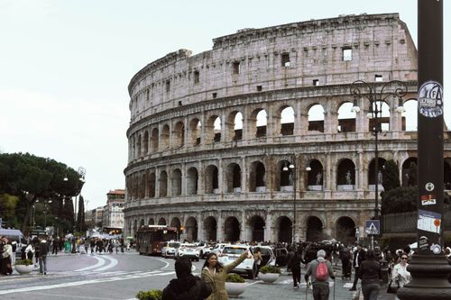 Free Photo of the Colosseum in Rome, Italy, with a lively street scene in the foreground. Stock Photo