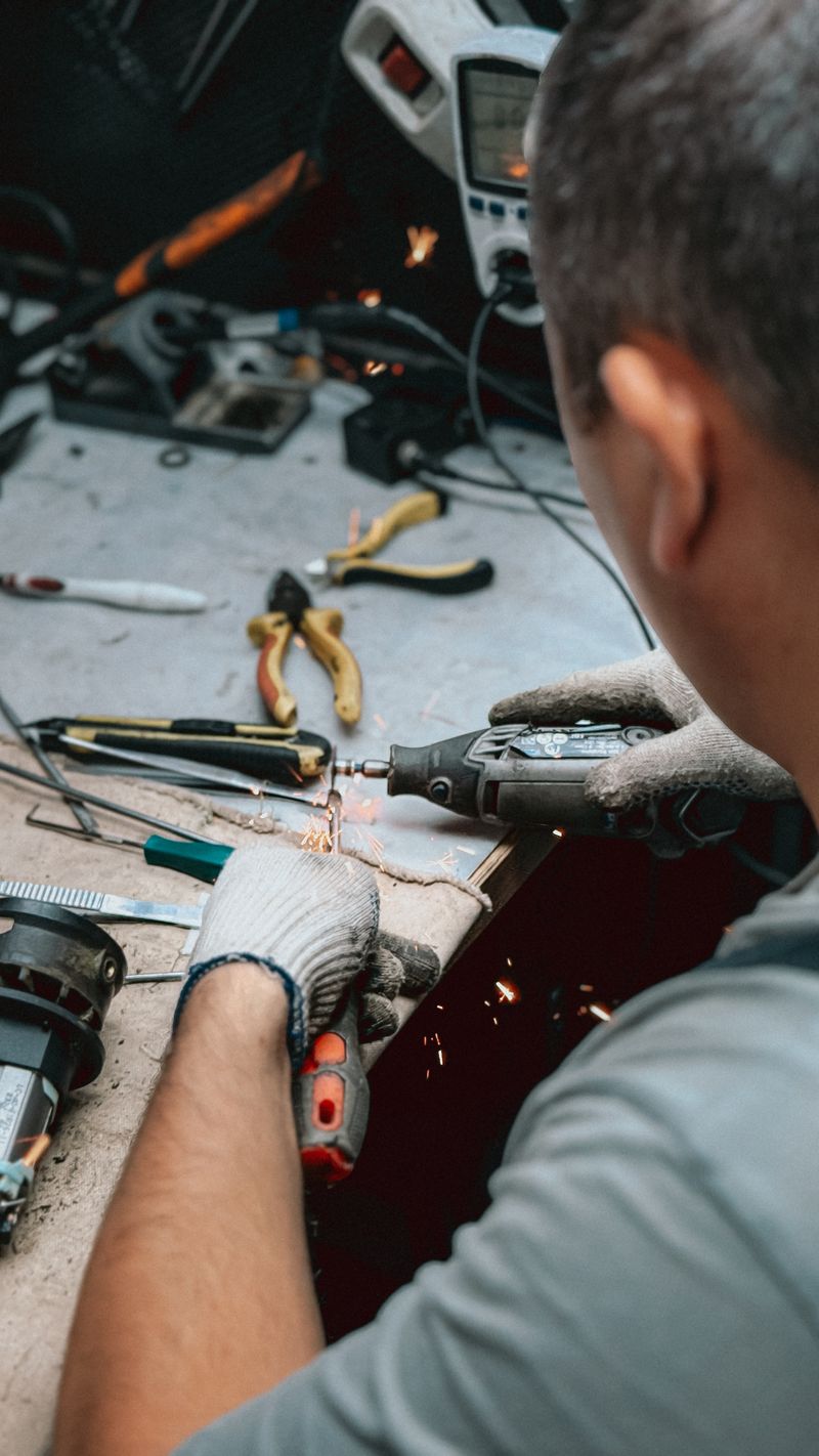 Craftsman using a power tool on a workbench