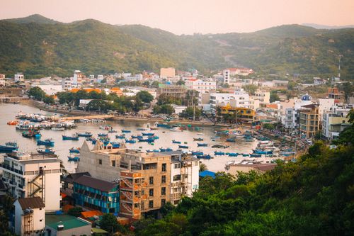 Free Explore the vibrant fishing harbor in Nha Trang, Vietnam, with colorful boats and bustling architecture. Stock Photo