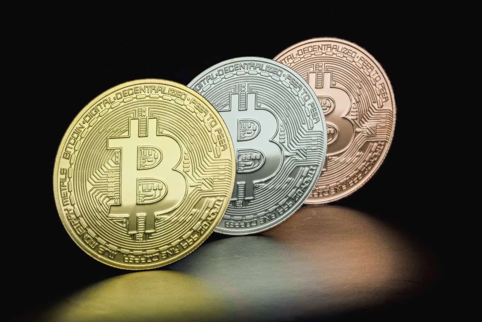 Close-up of Bitcoin coins in gold, silver, and bronze hues depicting cryptocurrency variety.