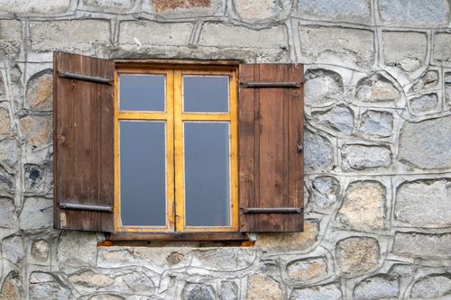 Free A rustic wooden window with shutters on a stone wall in Rize, showcasing traditional architecture. Stock Photo