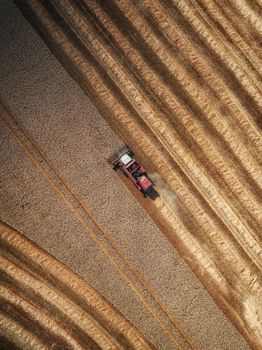 Drone captures a tractor harvesting fields in rural England, showcasing agricultural patterns.