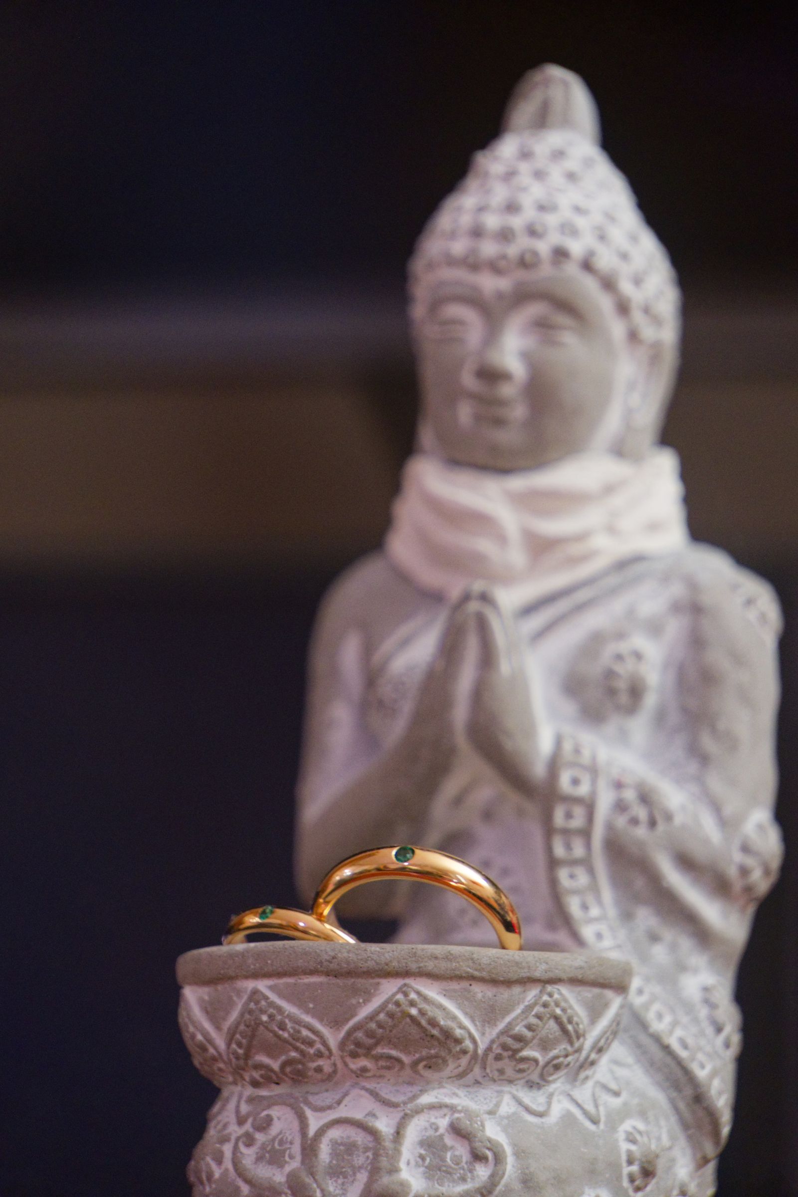 Alliances posées sur une petite statue de bouddha en méditation
